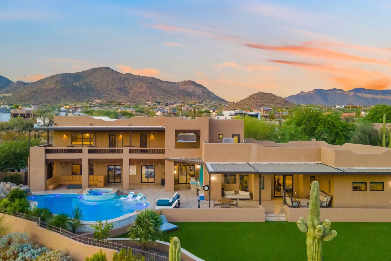 Mesa Grand Retreat from above at sunset: the pool, the lawn and the desert mountains behind